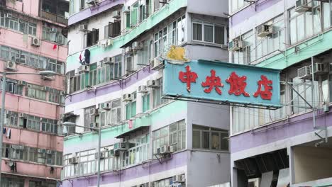 An-Der-Fassade-Eines-Farbenfrohen-Wohngebäudes-In-Hongkong-Hängt-Ein-Straßenleuchtreklame