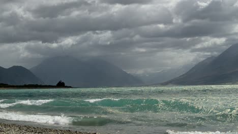 Heavy-storm-clouds-touching-peaks-of-alpine-mountain-range-at-Lake-Ohau,-New-Zealand