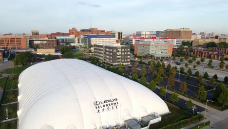 Aerial-ascending-shot-of-Lexus-Velodrome-during-golden-hour-with-a-city-skyline-on-a-nice-day