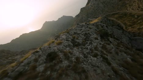 FPV-drone-shot-over-winding-Sa-Calobra-road-over-rocky-mountain-range-in-Mallorca,-Spain