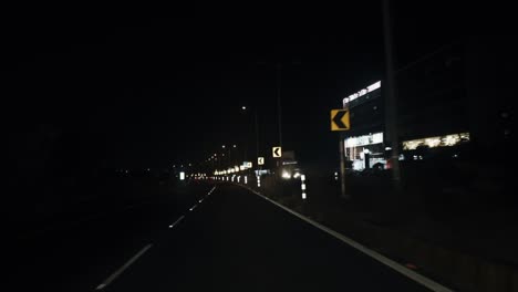 Curved-road-at-night-isolated-under-black-sky-with-light-reflected-from-traffic-lights-in-slow-motion