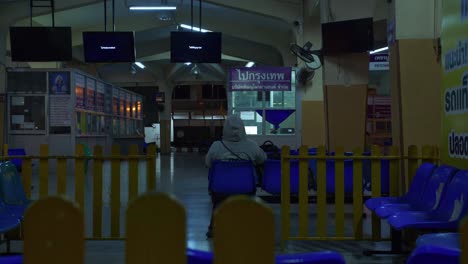 Terminal-De-Autobuses-Vacía-Por-La-Noche-Con-Solo-Una-Persona-Esperando-La-Salida,-Tailandia