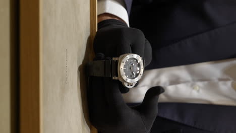 Vertikale-Aufnahme-Der-Hände-Eines-Verkäufers-In-Schwarzen-Handschuhen,-Der-In-Der-Boutique-Eine-Teure-Panerai-Luminor-Uhr-Präsentiert