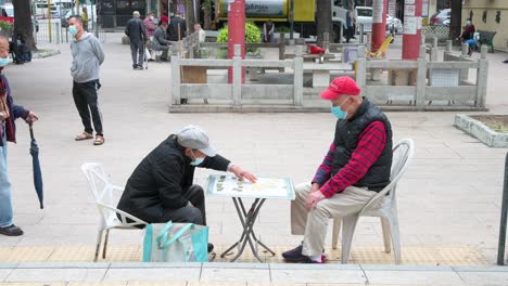 Ältere-Männer-Mit-Gesichtsmasken-Spielen-Schach-In-Einem-Park-In-Hongkong