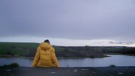 Lonely-Man-in-Yellow-Jacket-Sitting-in-Nature-and-thinks-about-Life