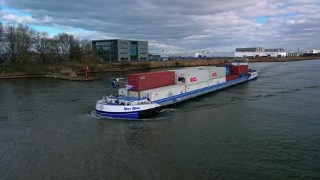 Aerial-parallax-shot-of-a-Mer-Blue's-vessel-sailing-in-a-river-in-Zwijndrecht-|-Rotterdam,-Netherlands