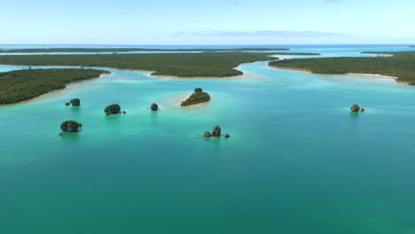 Pequeños-Islotes-Rocosos-En-La-Bahía-De-Upi,-Isla-De-Los-Pinos,-Nueva-Caledonia---Sobrevuelo-Aéreo