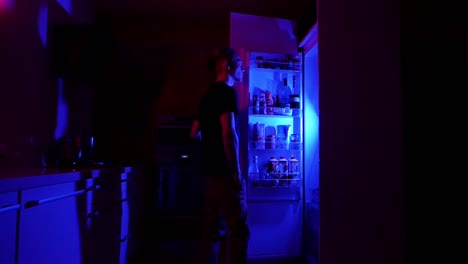 Teenager-eating-snacks-from-fridge-at-night