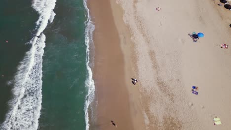An-aerial-drone-flies-over-top-of-the-beach-in-Sayulita-Mexico-with-some-people-on-the-sandy-beach-below