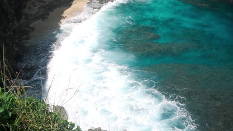 Top-view-of-crashing-wave-spreads-white-wash-over-Broken-Beach,-Nusa-Penida,-Bali