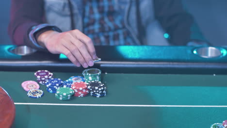 Ein-Professioneller-Pokerspieler-Am-Grünen-Tisch,-Der-Seine-Chips-Bewegt,-Während-Er-Darauf-Wartet,-Dass-Er-An-Die-Reihe-Kommt