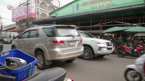 Nan-Province,-Thailand---November-22,-2022:-Shot-of-heavy-bikes-and-cars-movement-beside-a-local-market-in-Nan-City,-Thailand-at-daytime