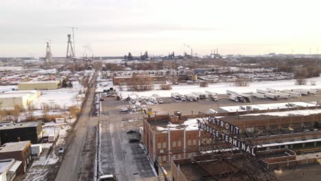 Aerial-ascending-shot-of-Detroits-industry-during-a-cold-winter-day-with-snow-covered-landscape,-establishing-shot