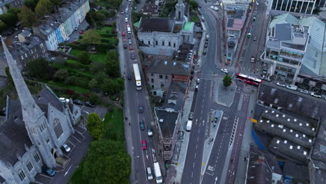 Downtown-Street-Traffic-And-Buildings-In-Cork-City,-Ireland---aerial-drone-shot