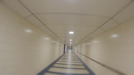 first-person-running-through-an-empty-airport-station-hall-passage