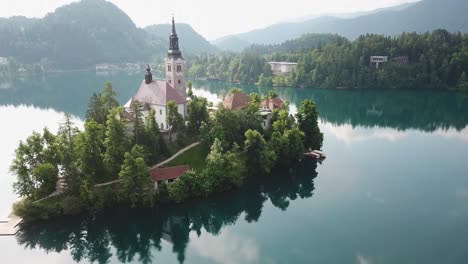 Close-up-aerial-view-of-a-church-in-the-middle-of-Lake-Bled-in-Slovenia's-countryside