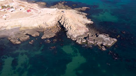 Aerial-orbit-around-sea-cliffs-of-Mexican-coastline-with-green-ocean-water