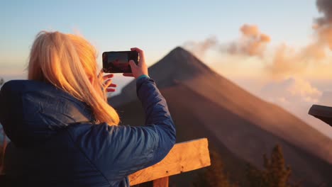 blonde,woman-filming-active-volcano-with-phone-in-guatemala