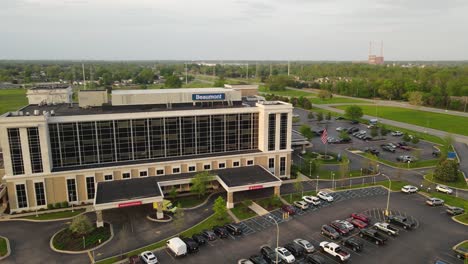 Beaumont-Health,-Hospital-entrance-and-parking-lot-in-aerial-establishing-view,-Trenton-Michigan,-USA