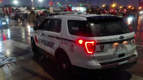 Close-up-panning-shot-of-a-police-car-parked-on-the-street-during-a-freedom-convoy-in-Windsor