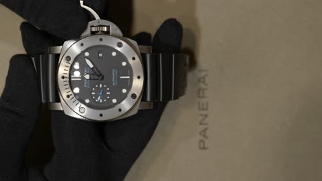 Dealer-Wearing-Gloves-Setting-The-Time-Of-Luxury-Wristwatch-In-Panerai-Boutique