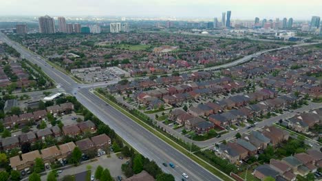 Flying-towards-the-downtown-city-area-of-Mississauga-with-large-buildings-and-many-house