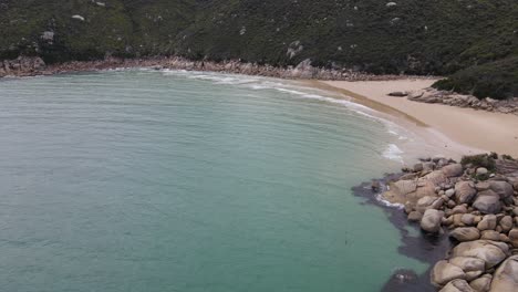 Drone-aerial-pan-down-over-beautiful-light-blue-beach-and-nice-sand-on-a-sunny-day-in-Wilsons-Promontory