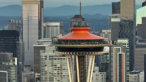 Tight-orbiting-aerial-shot-of-the-Seattle-Space-Needle's-observation-deck-with-skyscrapers-filling-the-background