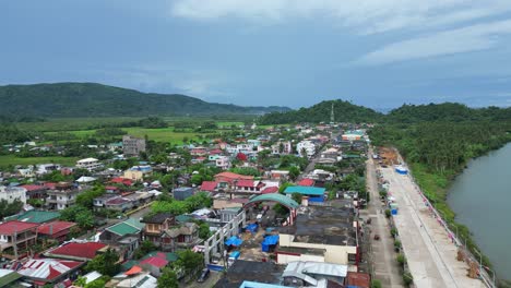 Establishing,-Idyllic-Drone-Shot-of-Riverside,-Local-Community-town-in-Bato,-Catanduanes