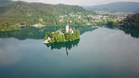 Wide-aerial-view-pushing-towards-an-island-structure-in-Lake-Bled,-Slovenia