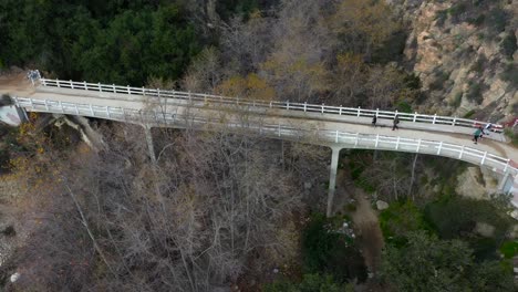 Chuck-Ballard-Memorial-Bridge-in-Angeles-National-Forest-with-hikers-crossing-on-an-overcast-day