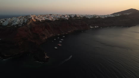 Luftaufnahme-Der-Griechischen-Insel-Santorini-In-Der-Abenddämmerung,-Der-Küste-Und-Den-Gebäuden-Auf-Hügeln