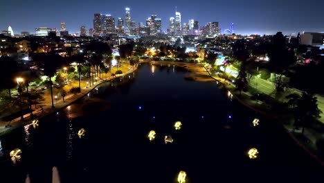 Echo-Park-Lake-with-the-Los-Angeles-City-skyline-at-twilight---aerial-flyover