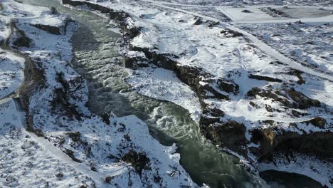 Fluss-Aus-Gletscherabfluss-In-Verschneiter-Isländischer-Landschaft,-Filmische-Luftaufnahme