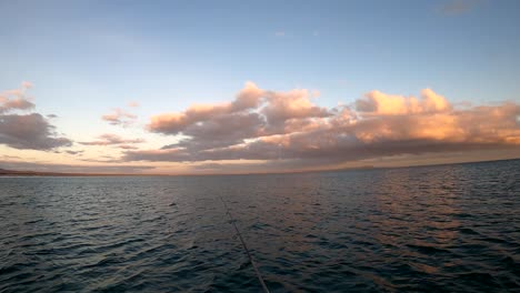 Fishermen-POV-casting-reel-rod-from-open-ocean-fishing-kayak-at-sunset