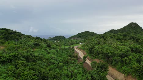 Aerial-View-of-Narrow,-hillside-Roadways-along-tropical-rainforests-in-the-Island-of-Catanduanes,-Philippines