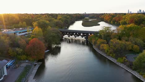 Drohne-Fliegt-Bei-Sonnenaufgang-Auf-Eine-Brücke-Zu,-Die-Einen-Mississauga-River-überquert