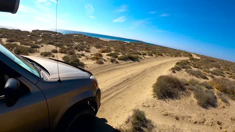 SUV-drives-quickly-down-bumpy-sandy-desert-road