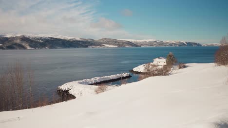 Blick-Auf-Eine-Hütte-Am-Schneebedeckten-Ufer-Des-Trondheimsfjords,-Trondheim,-Norwegen