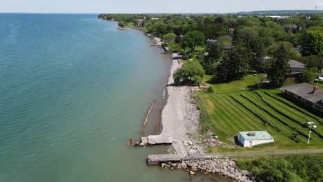 Drone-flying-away-from-Lake-Ontario-coastline-in-Grimsby-on-a-sunny-summer-day