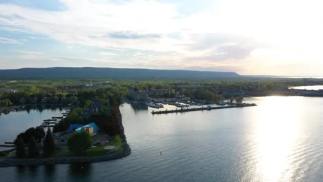 Drone-flying-around-houses-nestled-on-a-Lake-Ontario-peninsula-in-Collingwood-at-sunrise