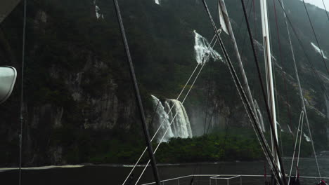 Falls-cascade-down-steep-slope-of-Milford-Sound-on-rainy-day