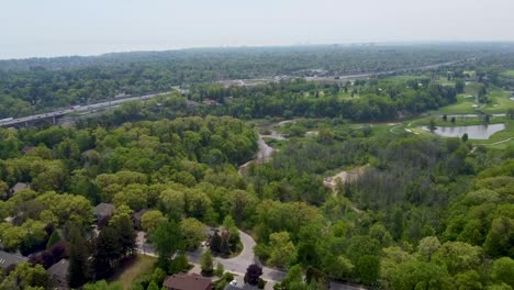 Flug-über-Grünflächen-In-Mississauga-Mit-Einem-Golfplatz-Und-Dem-Qew-Im-Hintergrund