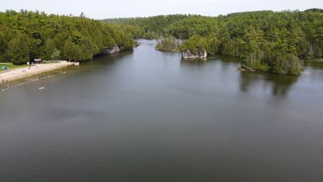 Drone-flying-over-a-lake-and-beach-in-Guelph