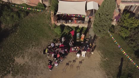 A-drone-shot-focused-on-a-group-of-people-outside-a-rural-big-house-in-Girona,-Spain