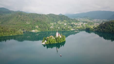 Aerial-view-pulling-away-from-the-Assumption-of-Maria-Church-in-the-middle-of-Slovenia's-Lake-Bled