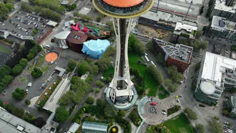 Unique-aerial-view-of-the-Seattle-Space-Needle,-tilting-down-to-show-crowds-of-people-on-the-observation-deck