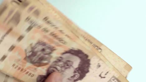 Primer-Plano-De-Los-Dedos-Contando-Billetes-Mexicanos-De-500-Pesos,-Fondo-Azul