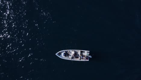 Birdseye-view-of-fishing-boat-in-deep-blue-open-ocean-water