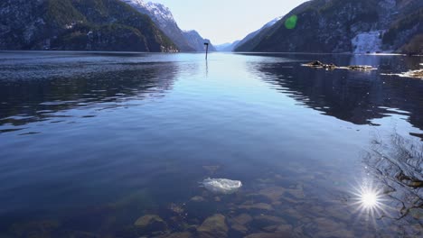 Scenic-Veafjorden-Fjord,-Norway-contrasted-by-plastic-waste-floating-near-shore